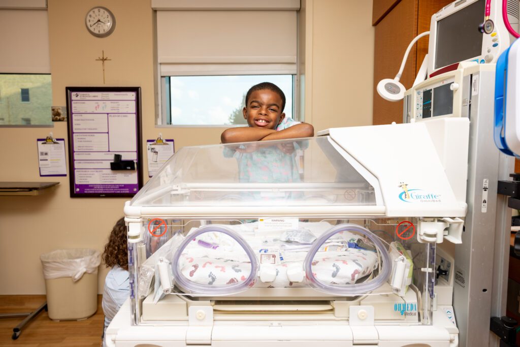 Champion Ian next to a NICU bed